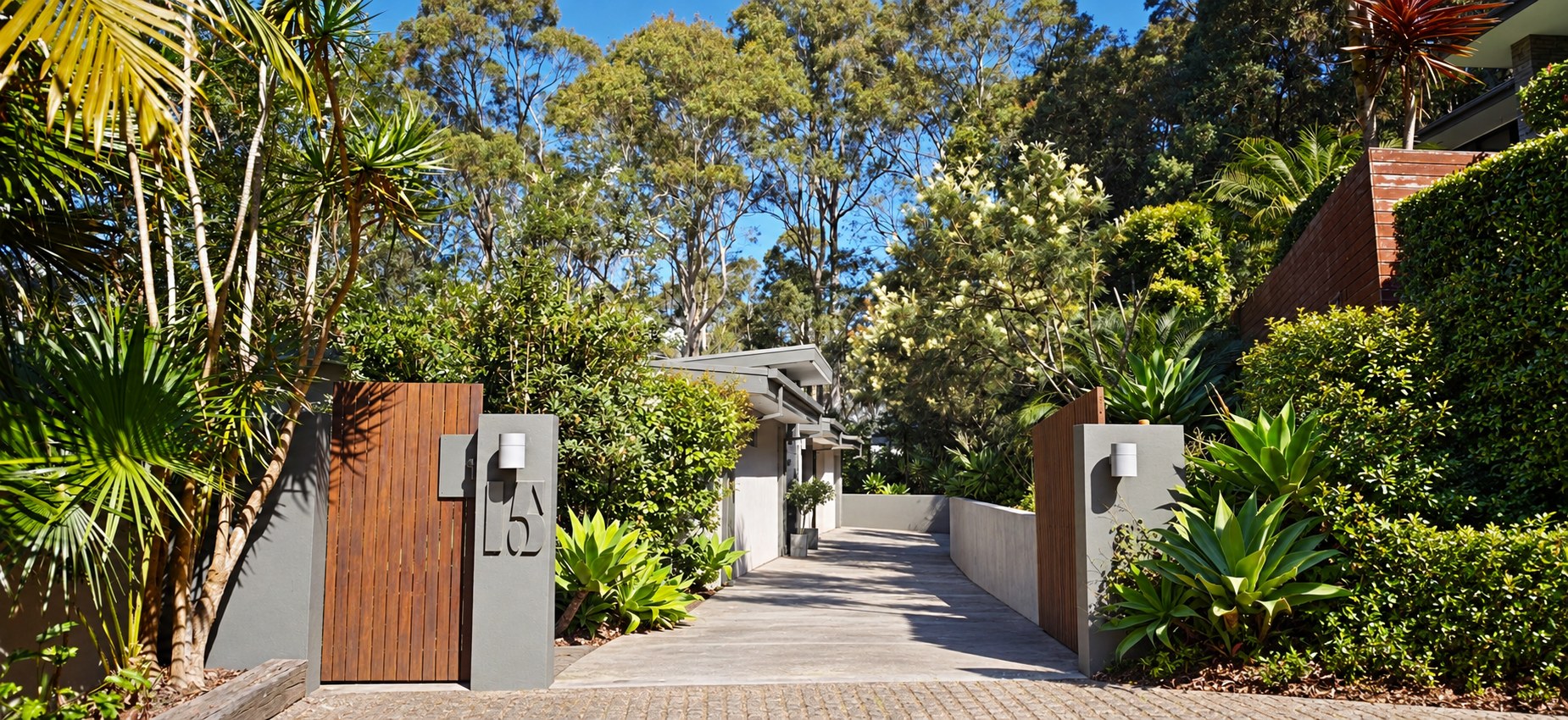 Landscaped gated entrance and level driveway to the residence